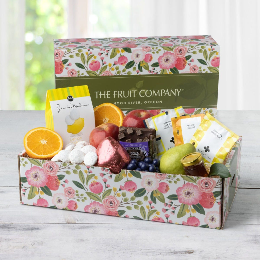 Delightful Mother's Day Summer Snack Gift Box Art of Tea brand packages of egyptian chamomile, apricot escape, and french lemon ginger Tight shot of lemon cookies with powdered sugar in the floral Mother's Day box